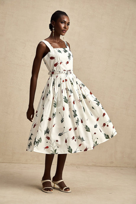 A floral print midi dress with a white background and colorful flower pattern featuring long sleeves and a flowy skirt