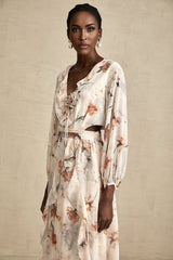 A floral print midi dress with an open waist design featuring a colorful pattern on a light background The dress has a feminine silhouette with a flowing skirt and likely includes details such as short sleeves or straps