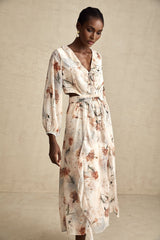 A floral print midi dress with an open waist design featuring a colorful pattern on a light background The dress has a flowing silhouette and appears to be made from a lightweight fabric suitable for warm weather