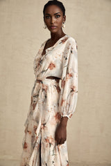 A floral print midi dress with an open waist design featuring a colorful pattern on a light background The dress has a flowing silhouette and appears to be made of a lightweight fabric suitable for warm weather