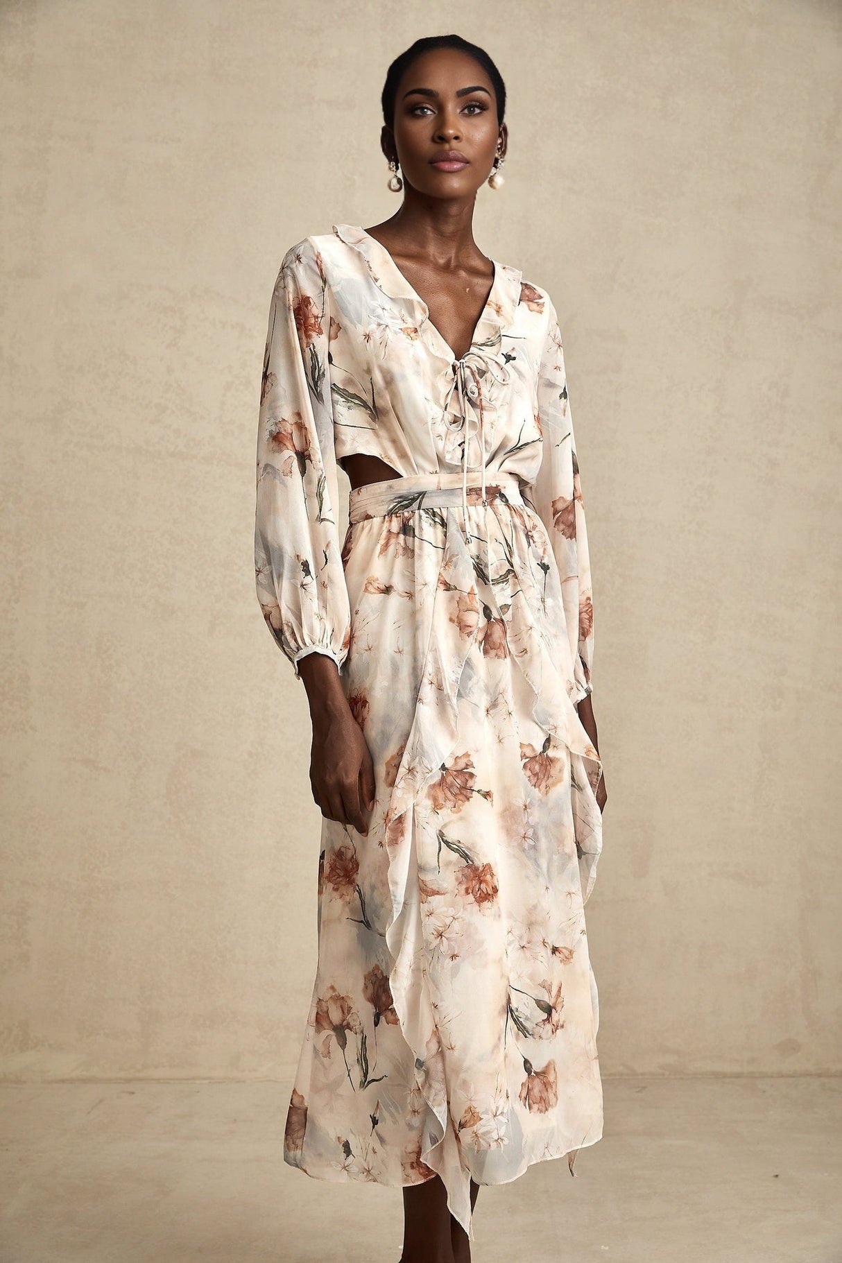 A floral print midi dress with an open waist design featuring a colorful pattern on a light background The dress has a flowing silhouette and appears to be made of lightweight fabric suitable for warmer weather