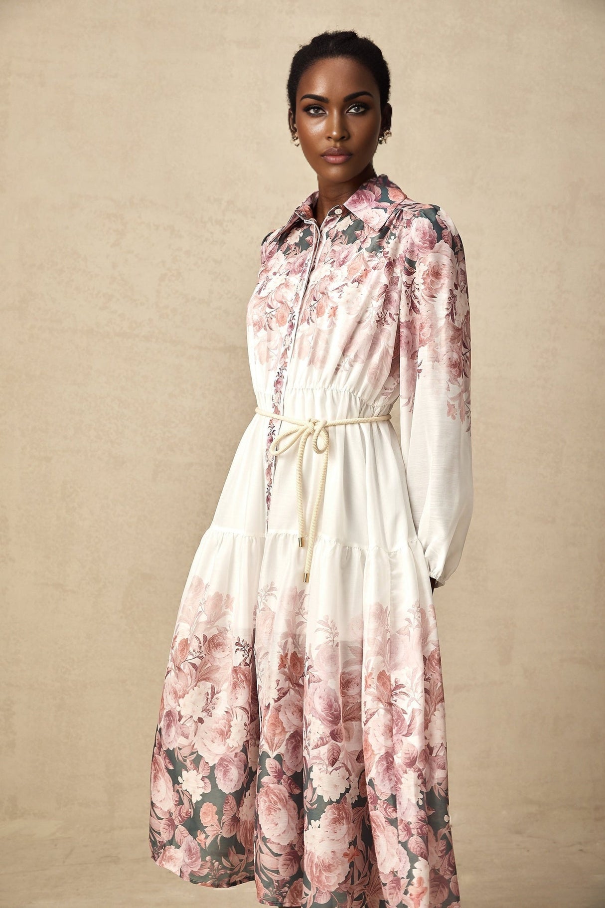 A floral print midi dress with lantern sleeves named Carina featuring a colorful pattern on a light background and a flowing silhouette that falls to mid calf length