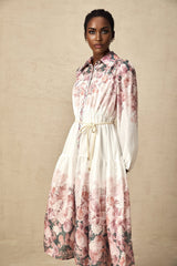 A floral print midi dress with lantern sleeves named Carina featuring a colorful pattern on a light background and a flowing silhouette that falls to mid calf length
