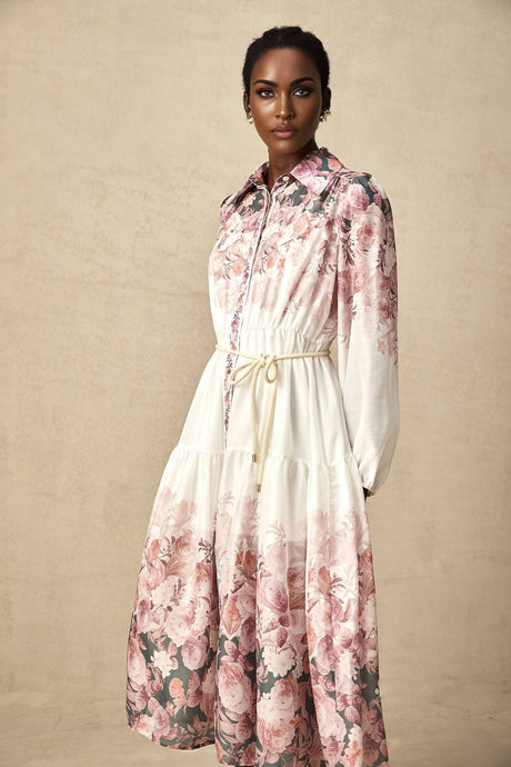 A floral print midi dress with lantern sleeves named Carina featuring a colorful pattern on a light background and a flowing silhouette that falls to mid calf length
