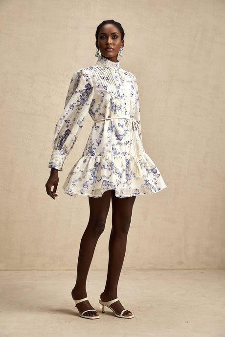 A floral print mini dress with a flared silhouette made from chiffon fabric featuring a colorful pattern on a light background with short sleeves and a flowing skirt