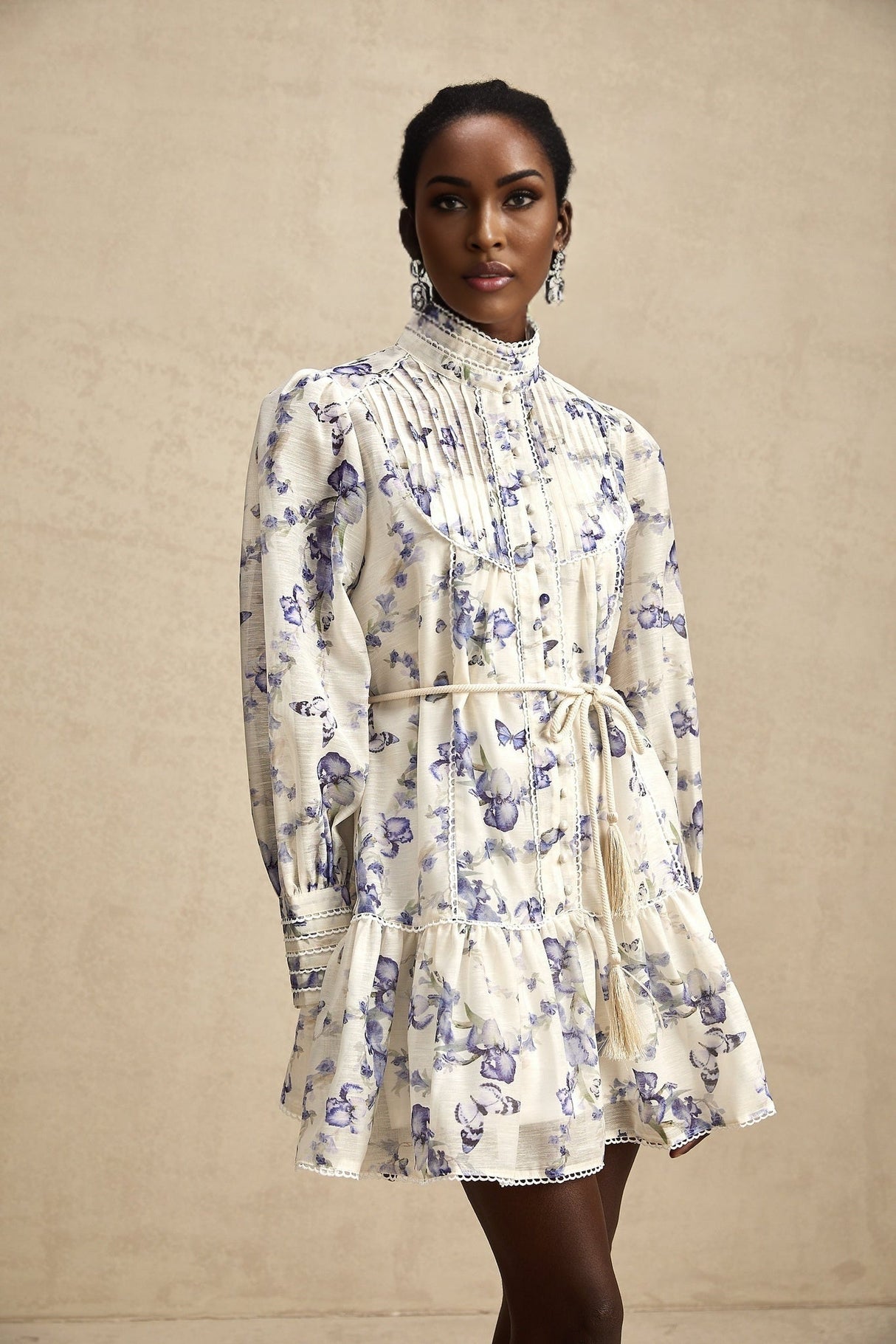 A floral print mini dress with a flared skirt made of chiffon fabric featuring a vibrant floral pattern on a light background with short sleeves and a fitted bodice