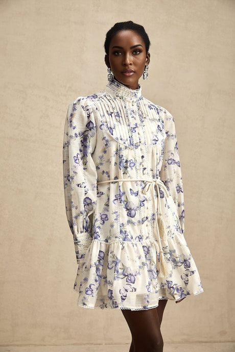 A floral print mini dress with a flared skirt made of chiffon fabric featuring a vibrant floral pattern on a light background with short sleeves and a fitted bodice