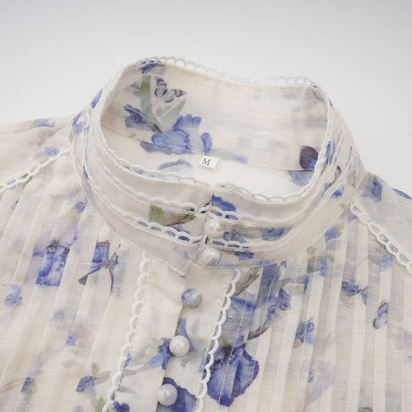 A floralprint mini dress with a flared chiffon skirt in light colors featuring a fitted bodice and short sleeves