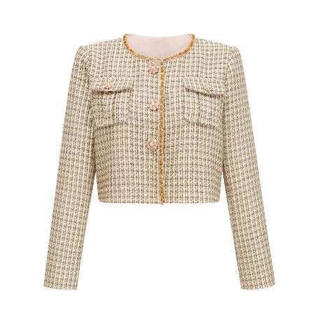 A gold tweed jacket and matching skirt set adorned with sequins creating a shimmering elegant ensemble