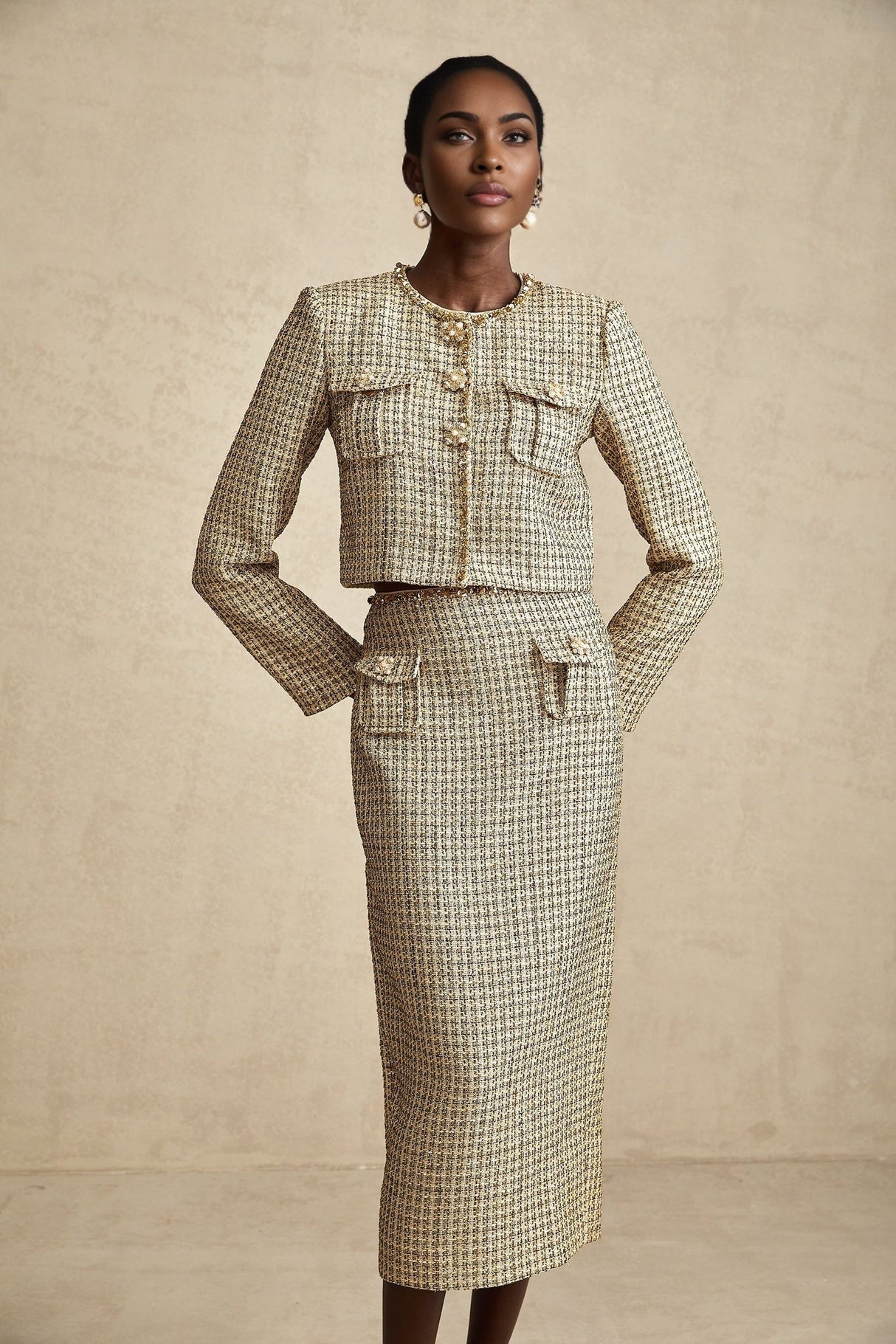A gold tweed jacket and matching skirt set adorned with sequins for a sparkly elegant look