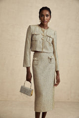 A gold tweed jacket and matching skirt set embellished with sequins creating a shimmering elegant ensemble