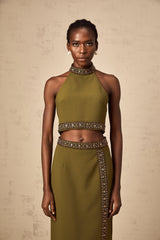 A green matching set featuring a top and skirt with daisyinspired beaded trim details