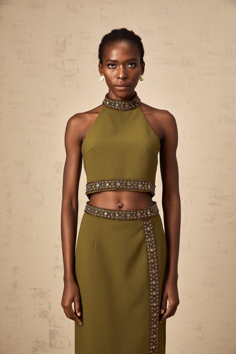 A green matching set featuring a top and skirt with daisyinspired beaded trim details