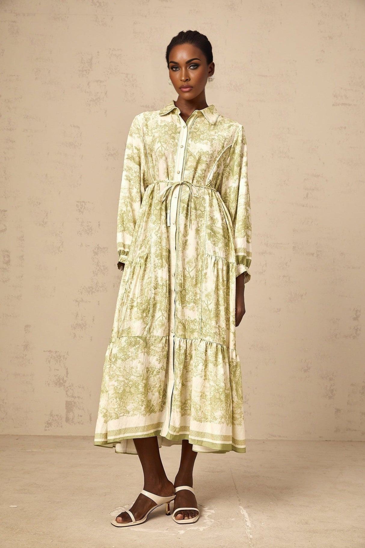 A green midi dress with a graphic print pattern called Adelaide worn by a model standing against a plain background