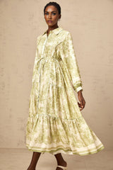 A green midi dress with a graphic print pattern named Adelaide worn by a model standing in a neutral background