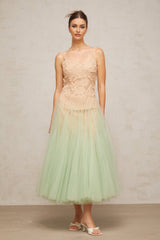 A green midi dress with lace panelling and tulle fabric featuring a feminine silhouette and delicate details