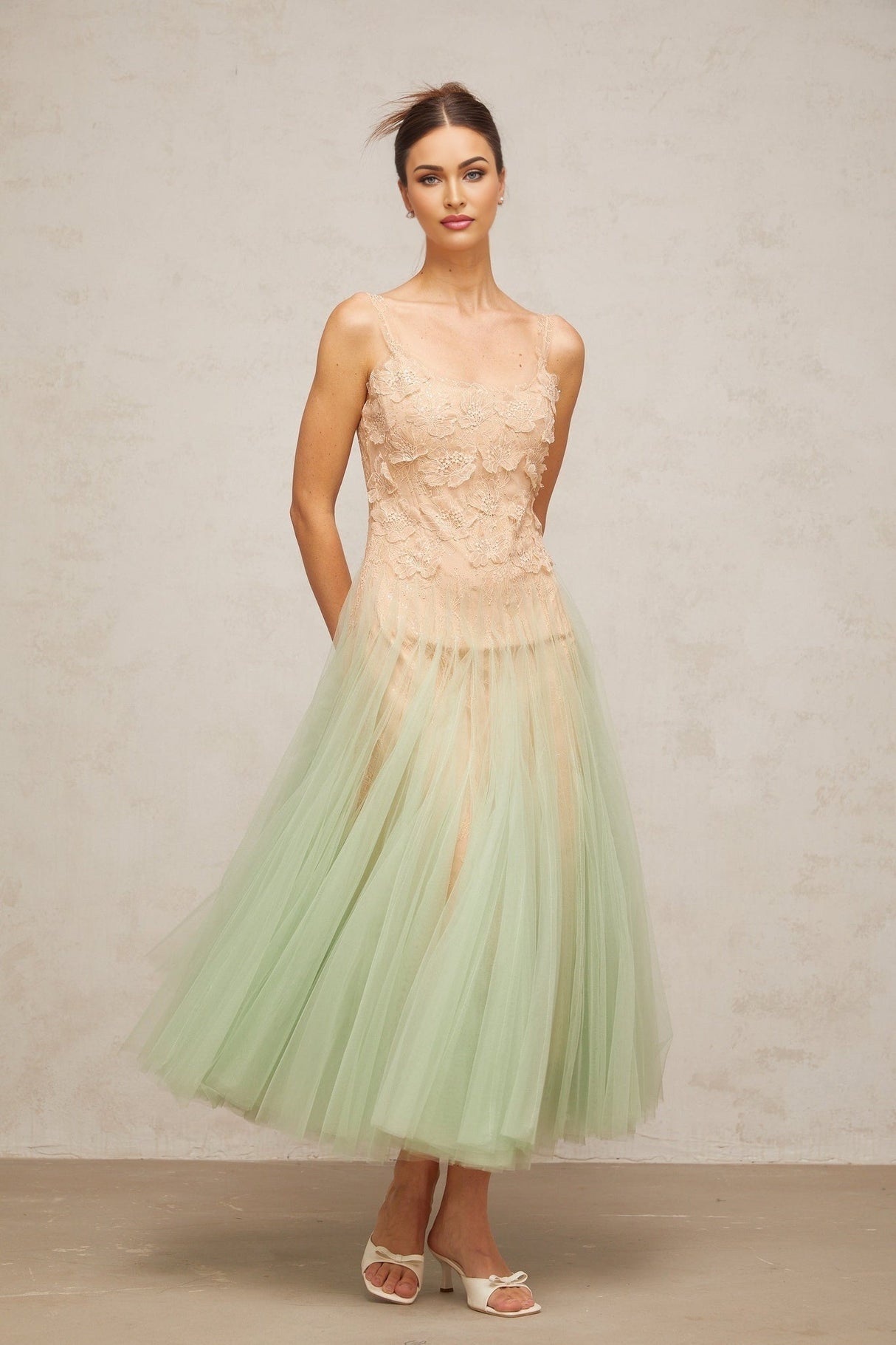 A green midi dress with lace panelling and tulle fabric featuring a slim silhouette and delicate details