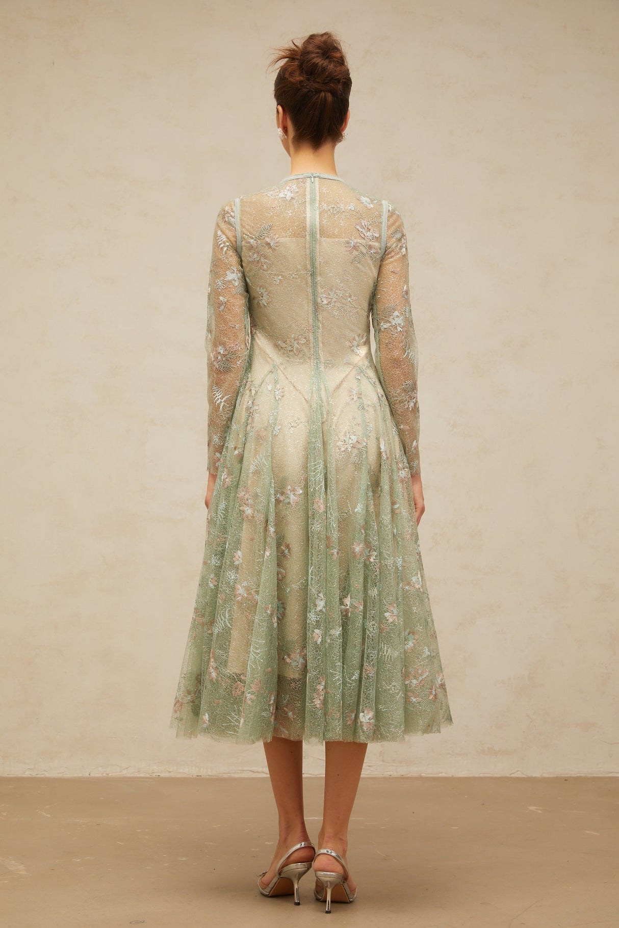A green pleated midi dress with floral embroidery details featuring a design called Philomene