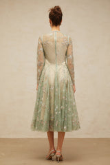 A green pleated midi dress with floral embroidery details featuring a design called Philomene