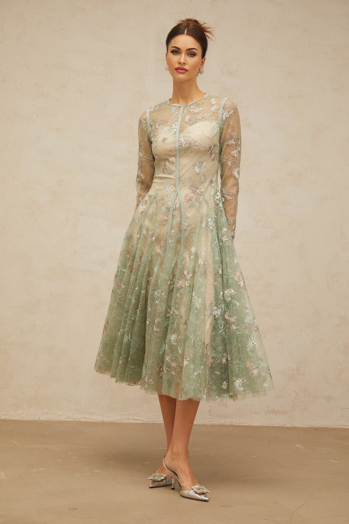 A green pleated midi dress with floral embroidery details featuring a design called Philomene