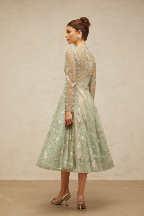 A green pleated midi dress with floral embroidery details named Philomene featuring a feminine silhouette and delicate floral accents