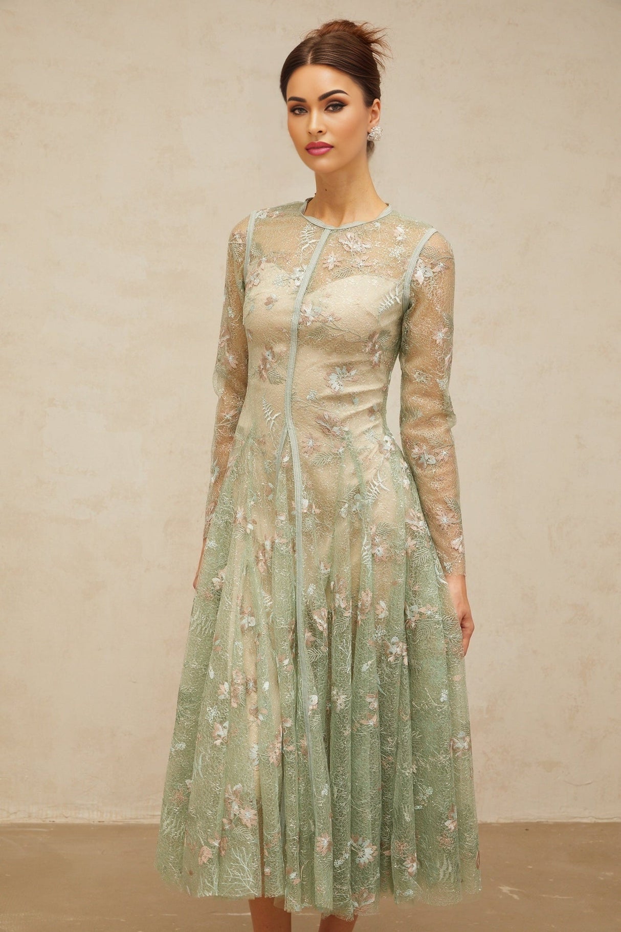 A green pleated midi dress with floral embroidery details named Philomene shown on a mannequin or model against a plain background