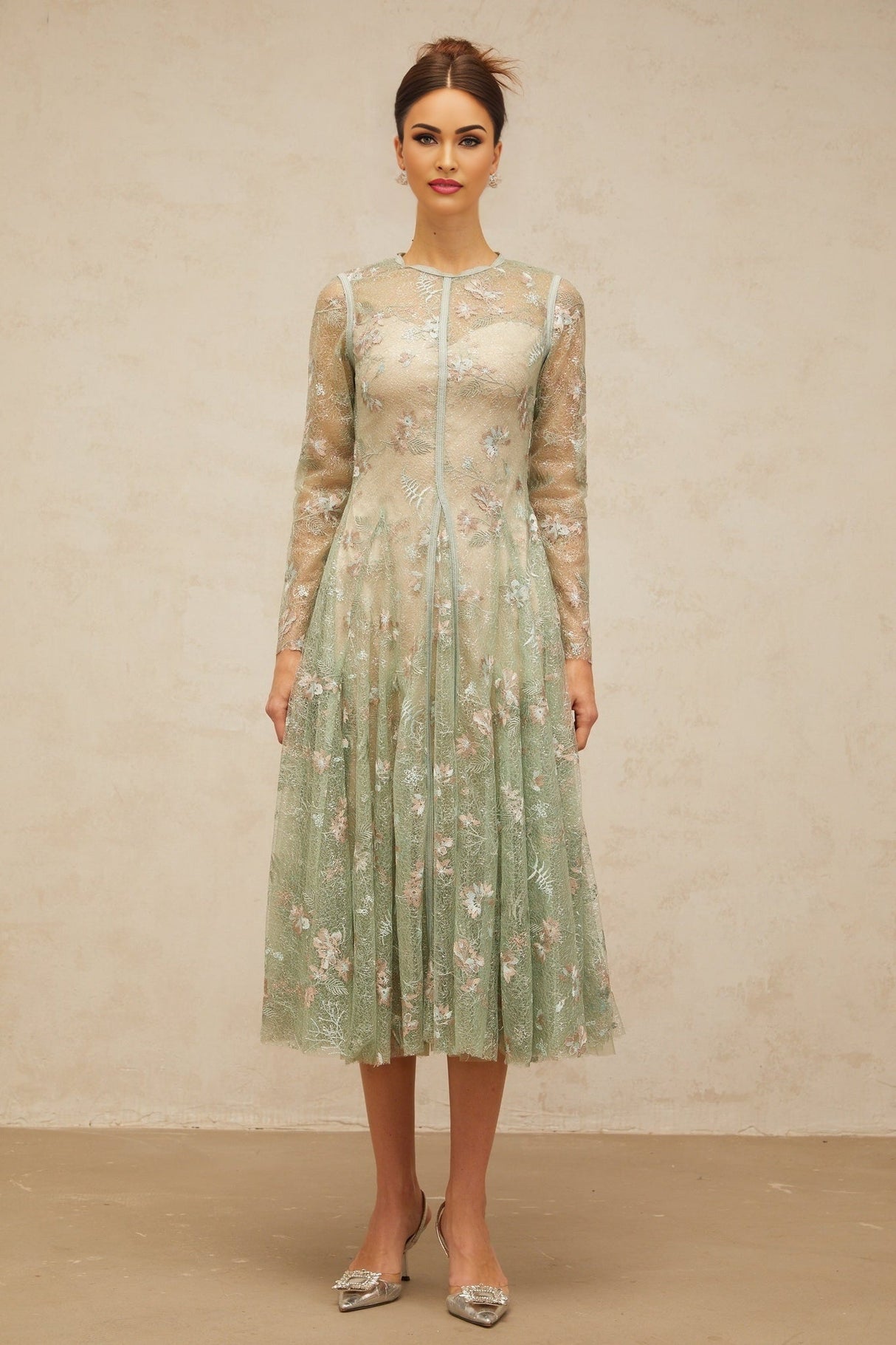 A green pleated midi dress with floral embroidery featuring a design called Philomene