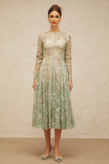 A green pleated midi dress with floral embroidery featuring a design called Philomene