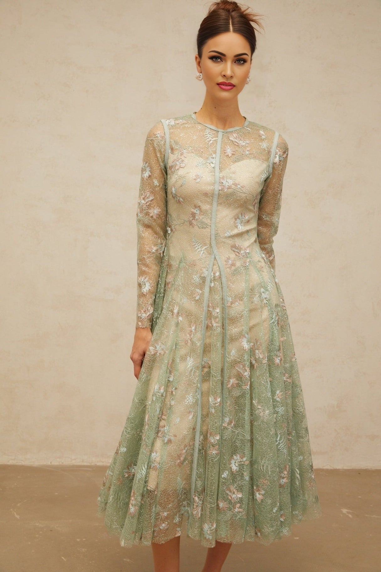 A green pleated midi dress with floral embroidery named Philomene featuring a flowing silhouette and delicate flower details throughout the fabric