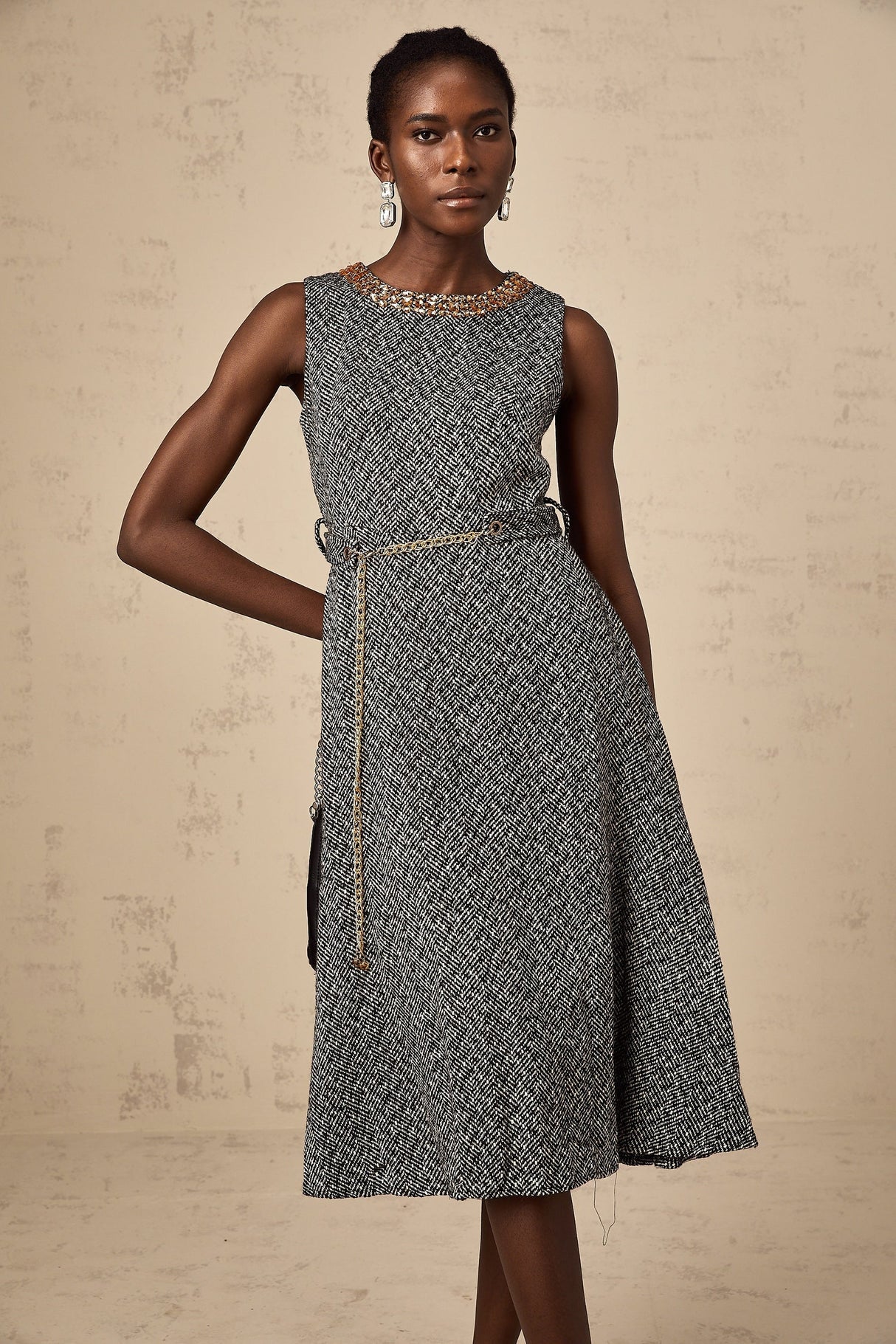 A grey sleeveless tweed midi dress with crystal embellishments suitable for Valentines Day occasion featuring a fitted silhouette and textured fabric