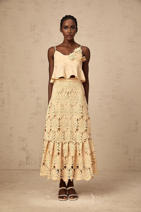 A khaki colored matching set consisting of a flared top with cutout details and a coordinating skirt designed by Celine