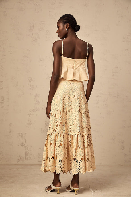 A khaki colored matching set featuring a flared top with cut out details and a coordinating skirt by Celine