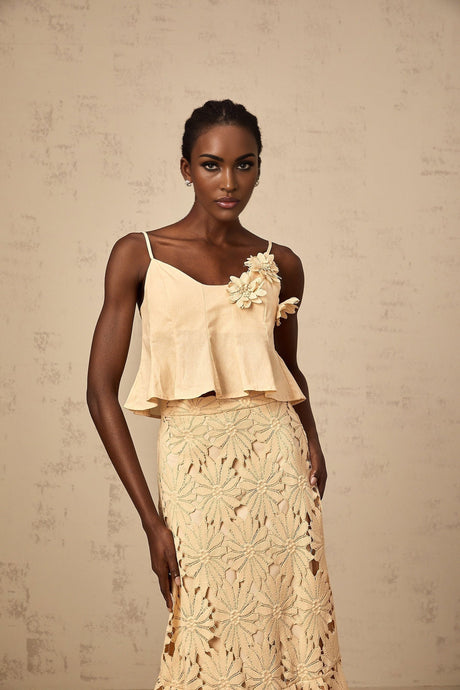 A khaki colored matching set featuring a flared top with cut out details and a coordinating skirt designed by Celine