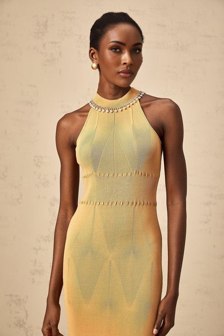 A knit midi dress in a light color with faux pearl embellishments scattered across the fabric named Juliette