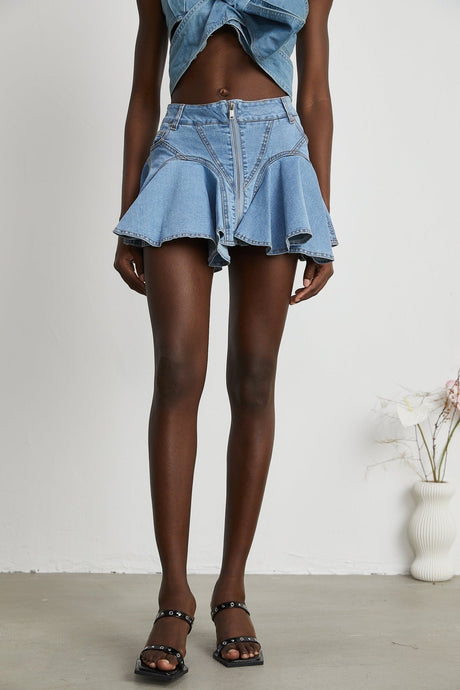 A light blue denim skirt with a ruffled hem featuring a volant detail at the bottom The skirt has a capucine style with a slightly flared silhouette