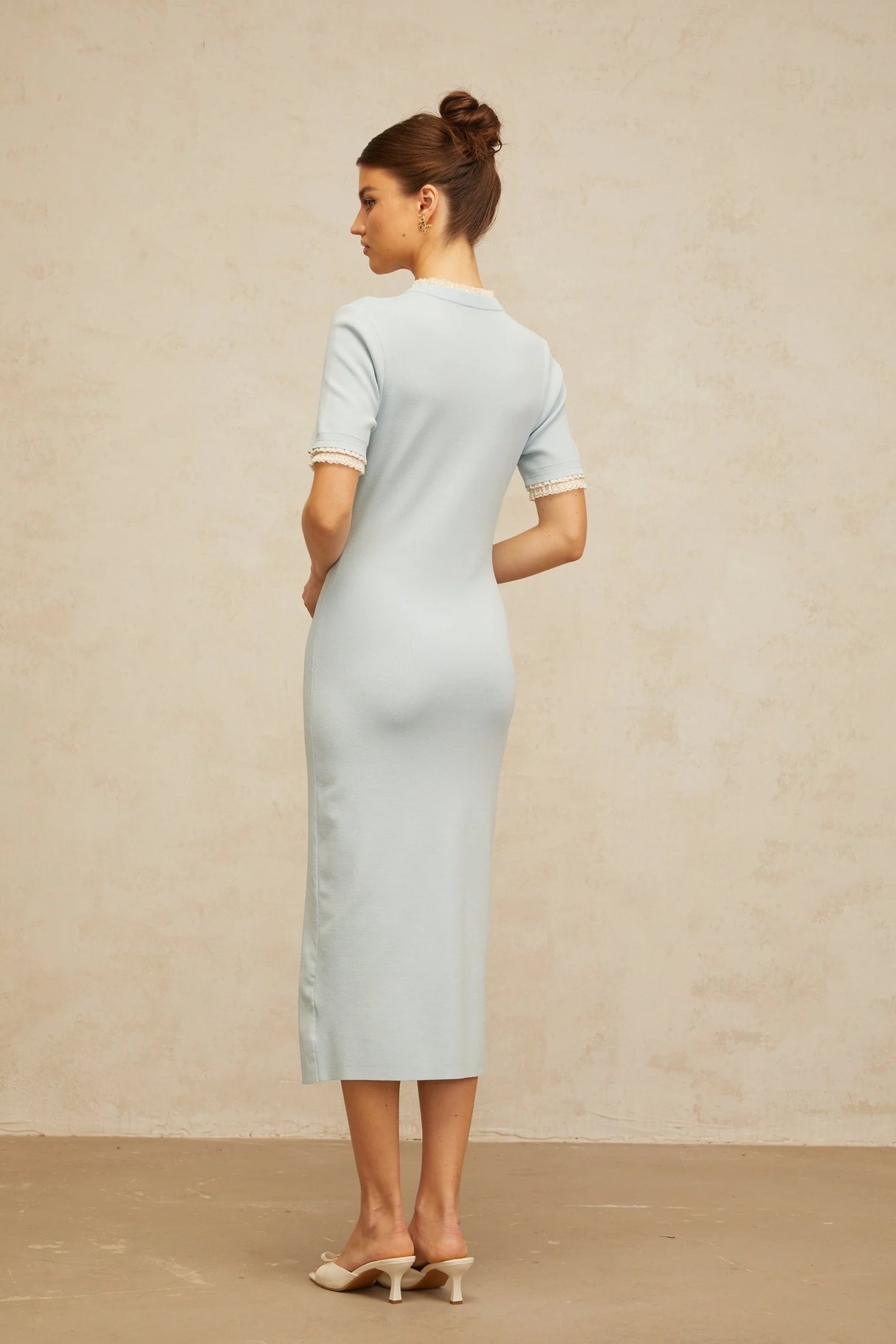 A light blue knit midi dress with a pencil silhouette featuring a fitted shape that hugs the body