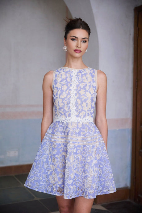 A light blue mini dress with crochet lace detailing and puff sleeves on a white background