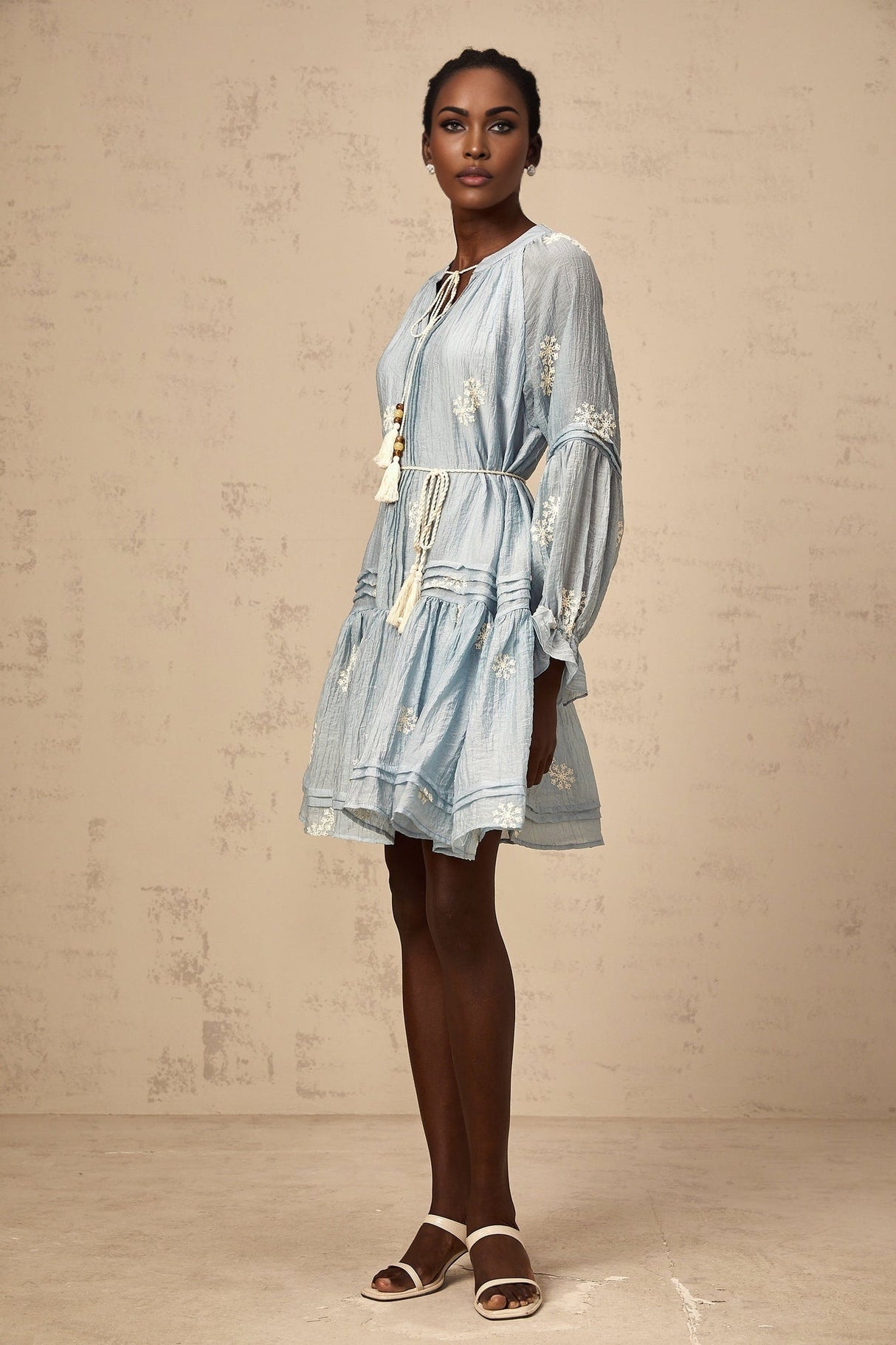 A light blue mini dress with delicate floral embroidery details and a feminine silhouette