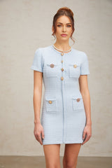 A light blue short knit dress adorned with sparkling crystal embellishments featuring a fitted silhouette and mini length