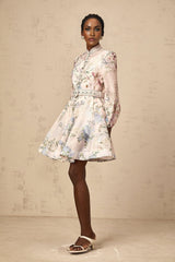 A light pink mini dress with a floral print pattern covering the entire garment