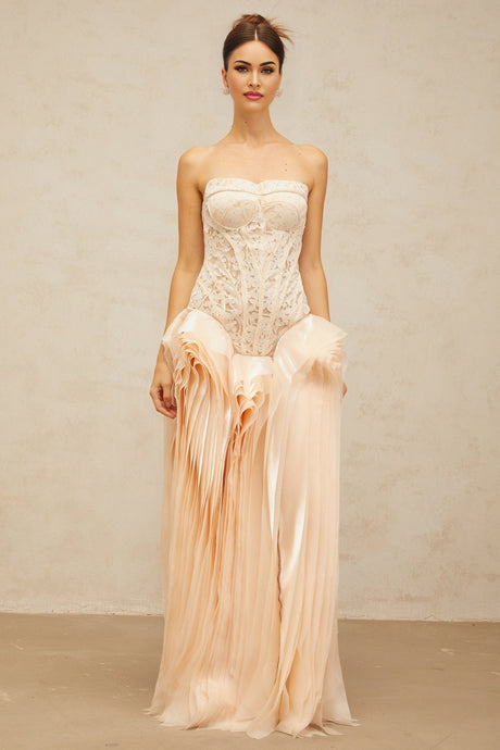A long beige maxi dress with lace detailing and a corset bodice featuring layered fabric and a neutral color palette