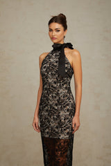 A long black maxi dress with a halter neckline featuring delicate floral lace pattern throughout the garment