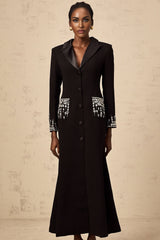 A long black maxi dress with blazer style top featuring embellishments worn by a model against a plain background
