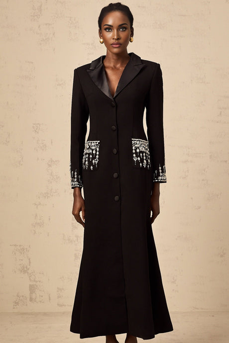 A long black maxi dress with blazer style top featuring embellishments worn by a model against a plain background