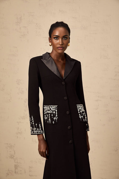 A long black maxi dress with blazer style top featuring embellishments worn by a model
