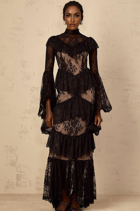 A long black maxi dress with floral lace details and ruffled accents worn by a model against a plain background