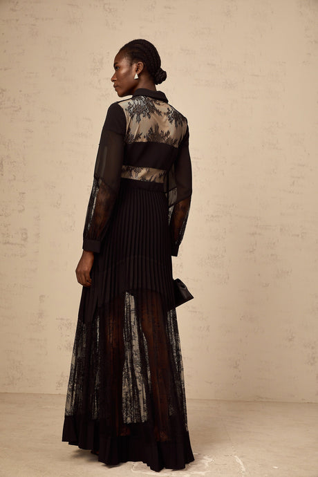 A long black maxi dress with pleated skirt and floral lace panels featuring a feminine silhouette and elegant design