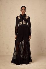 A long black maxi dress with pleats and floral lace panels featuring a feminine silhouette and elegant design