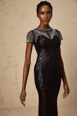 A long black maxi dress with sequin details and cutout design worn by a model