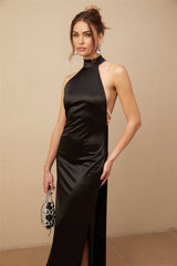 A long black satin maxi dress with a halter neckline adorned with faux pearls